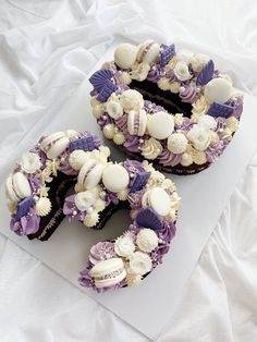 two cupcakes with purple and white frosting are arranged in the shape of the letter s