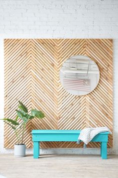 a blue bench sitting in front of a wooden wall with a mirror on top of it