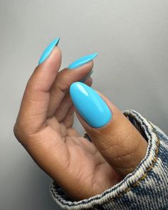 a woman's hand with bright blue nail polish on it, holding up her fingers