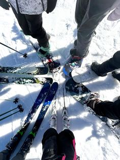 a group of people standing in the snow with skis and poles on their feet