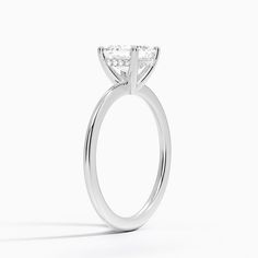 a close up view of a diamond ring on a white background with the center stone missing