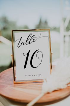 the guest book is placed on top of a wooden table with a white feather in it