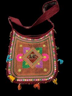 Description The Ethnic Multicolored Elegant Embellished Kutchi Style Shoulder Bag is a beautiful fusion of art, tradition, and functionality. It represents the heritage and craftsmanship of the Kutch region while serving as a unique and eye-catching accessory that adds a touch of ethnic charm and cultural elegance to any outfit. The bag’s construction is typically robust, ensuring it can withstand daily use while retaining its aesthetic appeal. It often comes with sturdy shoulder straps th Traditional Beaded Bags For Festivals, Traditional Beaded Shoulder Bag As Gift, Handmade Bags For Navratri, Red Handwork Shoulder Bag For Festivals, Traditional Handmade Bags For Navratri, Traditional Red Beaded Bags, Red Shoulder Bag With Handwork For Festivals, Festival Red Shoulder Bag With Handwork, Vintage Multicolor Bags For Festivals