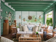 a living room filled with furniture and lots of green wall covering the walls in front of it