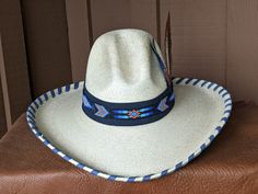 Been wanting to make a hat with dark blue suede. This is the first one - Salado! It starts with this most popular and very flattering palm Gus hat body. It has a 4" brim and a 5 1/4" crown. It is hand laced in denim blue leather lace. The hatband has a base of dark blue suede and topped with this incredibly colorful blue and black beaded hatband. Check out the feather assortment as it is the perfect complement. Note: Please allow 3-4 weeks. Fitted Panama Hat For Rodeo With Flat Crown, Western Panama Hat With Flat Crown, Western Style Fitted Panama Hat With Flat Crown, Western Blue Sun Hat With Flat Brim, Blue Curved Brim Sun Hat For Rodeo, Western Style Blue Sun Hat With Flat Brim, Western Blue Wide Brim Sun Hat, Blue Brimmed Straw Hat For Rodeo, Blue Western Straw Hat With Curved Brim