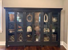 a black china cabinet with glass doors on the front and sides filled with decorative items