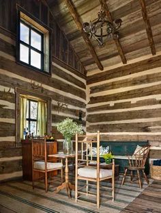 the interior of a log cabin with wood walls and flooring is decorated in rustic style