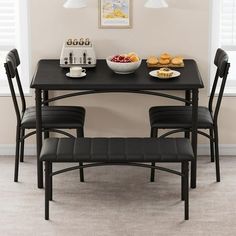 a dining table with two chairs and plates of food on it, in front of a window