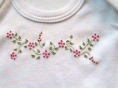 a white shirt with pink flowers embroidered on it