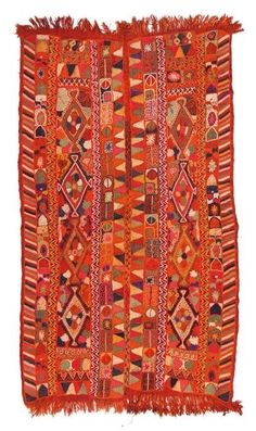 an orange and red rug with fringes on the bottom, in different colors and shapes