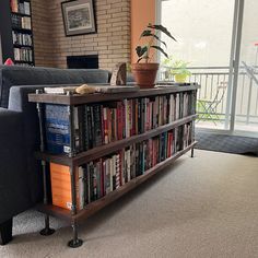 a living room filled with furniture and a bookshelf next to a large window