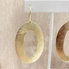 "These handcrafted earrings are modern and chic! Large gold circular hoops measuring over 2 inches long by 1.5 inches wide dangle from matching fish hooks. Earring material is brass dipped in brushed gold and lacquered with a protective varnish to prevent tarnish. Such beautiful texture! The earrings measure approximately 2.75\" in total length. A fabulous chunky look in a super lightweight style! Item is carefully packaged and shipped via USPS in a sturdy protective mailer. Check out more fabul Modern Oval Earrings With Ear Wire, Modern Oval Single Earring, Modern Gold Round Earrings, Modern Matte Gold Earrings, Modern Small Hoop Hammered Earrings, Modern Hammered Drop Hoop Earrings, Modern Hammered Small Hoop Earrings, Modern Gold Open Circle Earrings, Modern Yellow Gold Hoop Earrings