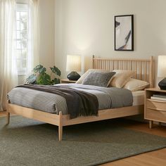 a bed room with a neatly made bed and two night stands on the side tables