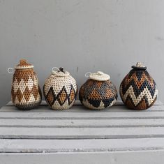 three crocheted jars sitting on top of a wooden table next to each other