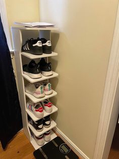 there is a skateboard on the floor next to a shoe rack that has several pairs of shoes in it