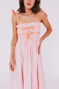 Get ready for a stylish and fun summer with our Sweet Simplicity Dress! This dress features tie straps and ribbons around the bodice for a unique look. The smocked top adds a touch of comfort and versatility. Perfect for any occasion, this dress is the epitome of sweet simplicity. Details Tie straps Ribbons around bodice Smocked top Baby pink with orange detailing Midi length Sizing Approximate measurements: SIZE LENGTH BUST Small 48" 26" Medium 51" 30" Large 53" 32" Fabric has in-bodice stretch Simplicity Dress, Smocked Top, Fun Summer, Get Ready, Baby Pink, Midi Length, Summer Fun, Smocking, Bodice