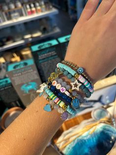 a woman's arm with bracelets on it and other items in the background