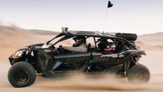 a black four - door buggy driving through the desert