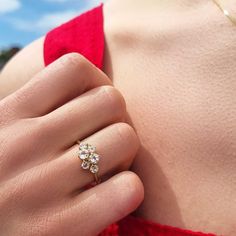 a woman's hand with a diamond ring on top of her shoulder, wearing a red dress