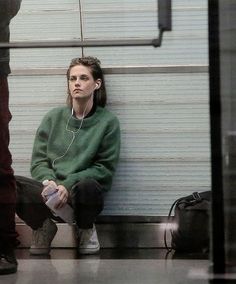 a woman sitting on the floor listening to music