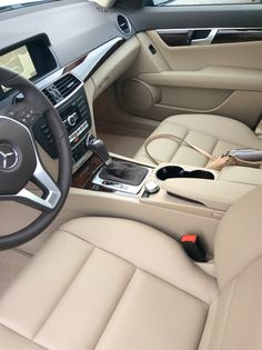 the interior of a car with beige leather seats and electronic devices on the steering wheel