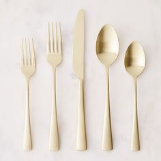 four forks, two spoons and one knife on a white surface