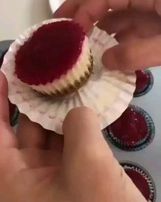 someone is holding onto some cupcakes with raspberry filling