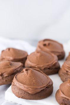 chocolate frosted cookies sitting on top of a white napkin