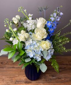 a blue vase filled with white and blue flowers