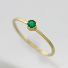 Handcrafted 14 carat yellow gold ring with a 3mm A grade faceted round Emerald stone in a bezel setting. Ring band measures 1mm wide and 1mm thick. Very dainty and elegant! Looks great stacked with other rings. Makes an excellent Mother's Ring! This item is made to order in your desired ring size, prices vary depending on requested size. Looks great paired with the necklace: https://www.etsy.com/listing/123058315/emerald-drop-necklace-in-14k-yellow-gold? Or the pendant: https://www.etsy.com/list Bezel Setting Ring, Mother's Ring, Drop Ring, Mother Rings, Emerald Stone, Emerald Engagement Ring, Yellow Gold Ring, Drop Necklace, Drop Pendant