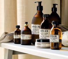 several different types of soaps and lotion bottles on a shelf next to a window