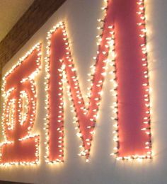 the word love spelled with lights in front of a white wall