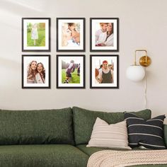 a living room with a green couch and four pictures on the wall above it,