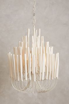 a white chandelier hanging from a chain with many sticks sticking out of it