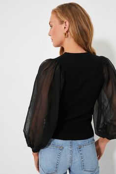 Not your average going out top — the Black Betsy Knit Blouse is the cool-girl closet update you've been needing. Featuring a classic high round neckline and a slim fitting bodice, complimented by fabulous, statement-making sheer balloon sleeves to add a hint of extra dimension. Perfect for pairing with mini skirts, denim, trousers and more for any evening plans on your social calendar, you're sure to get plenty of mileage out of this cool silhouette. Crewneck Long sheer balloon sleeves Fitted bo Chic Puff Sleeve Top For Winter, Stretch Crew Neck Puff Sleeve Top For Fall, Fitted Mesh Top With Crew Neck, Fine Knit Fitted Party Top, Black Top With Sheer Puff Sleeves, Chic Stretch Knit Top With Puff Sleeves, Fall Mesh Top With Sheer Sleeves And Crew Neck, Elegant Fall Puff Sleeve Top With Crew Neck, Spring Party Crew Neck Knit Top