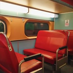 two red chairs sitting next to each other on a train