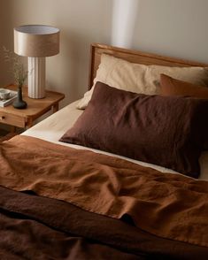 a bed with brown sheets and pillows in a bedroom