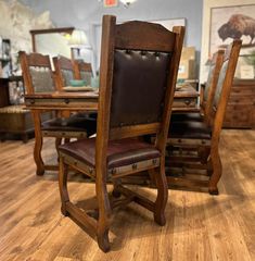 a dining room table with two chairs and a mirror