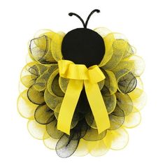 a yellow and black insect decoration on a white background