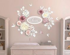 a baby's room with pink and white flowers on the wall