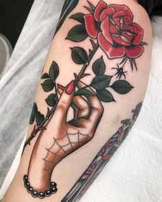 a tattoo with a rose on it and a person's hand holding the flower