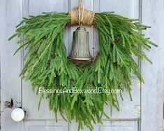 a green wreath with a bell hanging from it