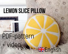 a lemon slice pillow sitting on top of a couch next to a framed photo and an english flag