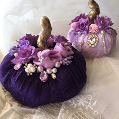 two purple pumpkins decorated with flowers and pearls