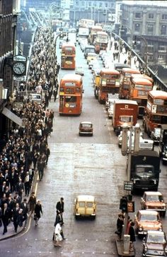 a busy city street filled with lots of traffic and people walking on the side walk