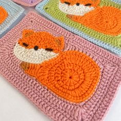 four crocheted coasters with animals on them, one is orange and the other is pink