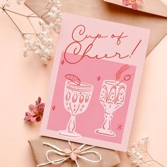 a pink greeting card with two champagne glasses