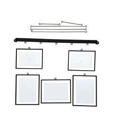 a set of four frames hanging on a white wall with black metal clips to hang them