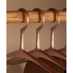 three wooden clothes hangers hanging on a rail