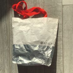 a white bag with a red ribbon hanging from it's handle on a wooden door